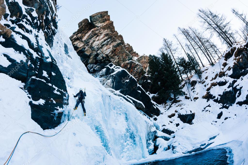 Ice climbing: male climber on a icefall in italian Alps. 