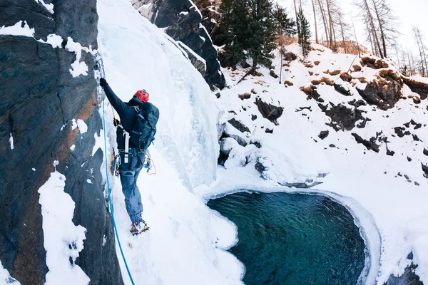 Lezení po ledu: muž horolezec na icefall v italských Alpách. Cogne (Val d'Aosta) - Itálie. — Stock fotografie