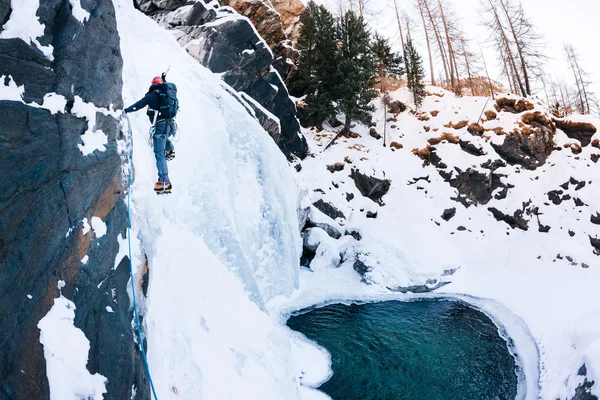 Lezení po ledu: muž horolezec na icefall v italských Alpách. Cogne (Val d'Aosta) - Itálie. — Stock fotografie