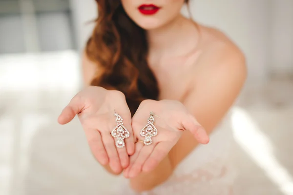 Een bruid is de mooie sieraden in de hand houden. — Stockfoto