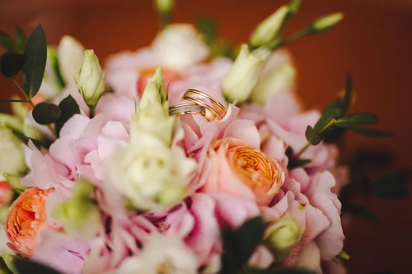 Dois anéis de casamento dourados em flores macro tiro — Fotografia de Stock