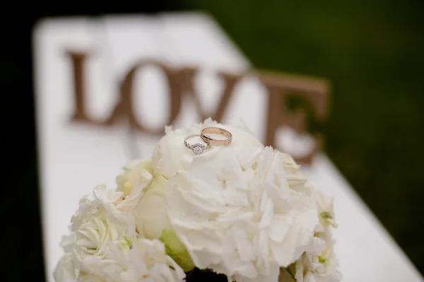 Zátiší se svatební kyticí a snubními prsteny — Stock fotografie
