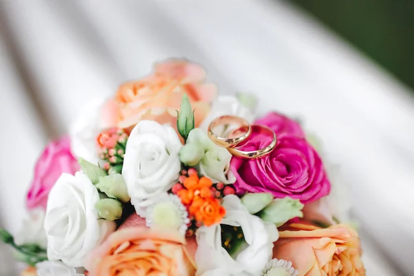 Dois anéis de casamento dourados em flores macro tiro — Fotografia de Stock