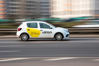 Ukrayna, Kyiv - 2 Mart 2021: Beyaz Taksi Uklon Renault Sandero arabası caddede ilerliyor