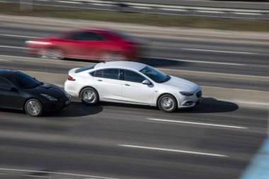 Ukrayna, Kyiv - 3 Mart 2021: Beyaz Opel Insignia - Siyah Toyota Celica arabası caddede ilerliyor;