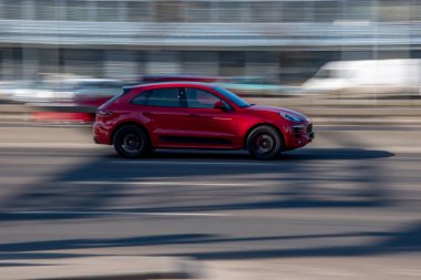 Ukrayna, Kyiv - 3 Mart 2021: Kırmızı Porsche Macan arabası sokakta hareket ediyor;