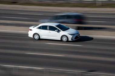 Ukrayna, Kyiv - 3 Mart 2021: Beyaz Toyota Corolla arabası yolda ilerliyor;