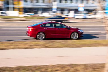 Ukrayna, Kyiv - 3 Mart 2021: Kırmızı Ford Mondeo arabası yolda ilerliyor;