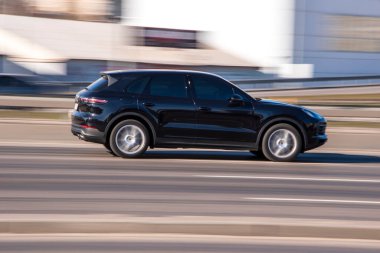 Ukrayna, Kyiv - 3 Mart 2021: Siyah Porsche Cayenne arabası sokakta hareket ediyor;