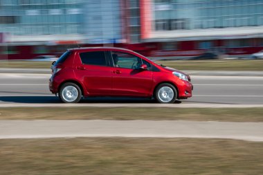 Ukrayna, Kyiv - 3 Mart 2021: Kırmızı Toyota Yaris arabası sokakta hareket ediyor;