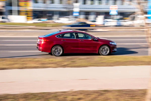 Ukrayna, Kyiv - 3 Mart 2021: Kırmızı Ford Mondeo arabası yolda ilerliyor;