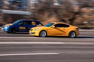 Ukrayna, Kyiv - 11 Mart 2021: Sarı Hyundai Genesis arabası sokakta ilerliyor;