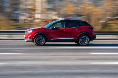 Ukrayna, Kyiv - 11 Mart 2021: Kırmızı Peugeot 2008 arabası sokakta hareket ediyor;