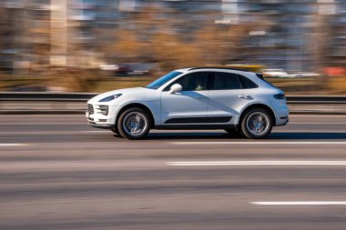 Ukrayna, Kyiv - 11 Mart 2021: Beyaz Porsche Macan arabası sokakta hareket ediyor;