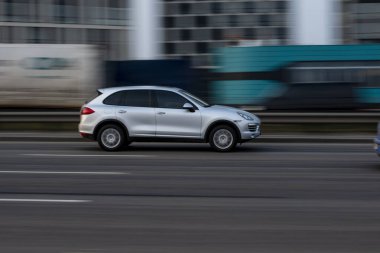Ukrayna, Kyiv - 11 Mart 2021: Beyaz Porsche Cayenne arabası sokakta hareket ediyor. Yazı