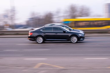 Ukrayna, Kyiv - 11 Mart 2021: Siyah Skoda Superb arabası sokakta hareket ediyor. Yazı