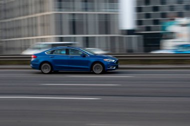 Ukrayna, Kyiv - 11 Mart 2021: Mavi Ford Fusion (Kuzey Amerika) arabası yolda ilerliyor. Yazı