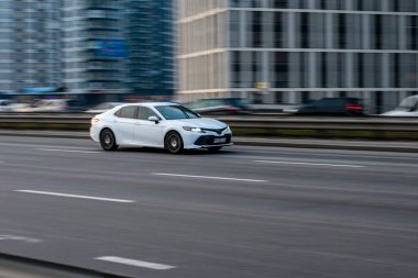 Ukrayna, Kyiv - 11 Mart 2021: Beyaz Toyota Camry arabası sokakta hareket ediyor. Yazı