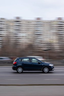 Ukrayna, Kyiv - 18 Mart 2021: Mavi Suzuki SX4car caddede ilerliyor.  