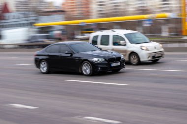 Ukrayna, Kyiv - 18 Mart 2021: Siyah BMW 5 Serisi araba yolda ilerliyor. 