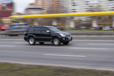 Ukrayna, Kyiv - 18 Mart 2021: Siyah Toyota arazi kruvazörü Prado arabası yolda ilerliyor.  