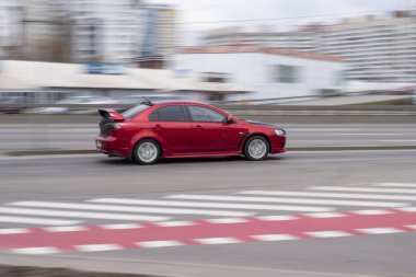 Ukrayna, Kyiv - 18 Mart 2021: Kırmızı Mitsubishi Lancer arabası yolda ilerliyor. 