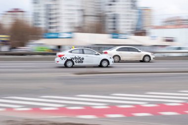 Ukrayna, Kyiv - 18 Mart 2021: Beyaz Hyundai Aksanı arabası sokakta hareket ediyor.  