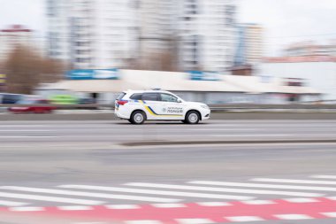 Ukrayna, Kyiv - 18 Mart 2021: Polis White Mitsubishi Outlander aracı caddede ilerliyor.  