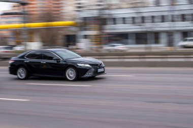Ukrayna, Kyiv - 18 Mart 2021: Siyah Toyota Camry arabası sokakta hareket ediyor. 