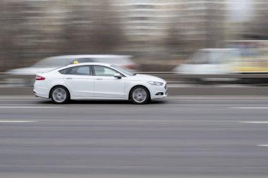 Ukrayna, Kyiv - 18 Mart 2021: Beyaz Ford Mondeo arabası yolda ilerliyor. 