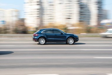 Ukrayna, Kyiv - 4 Nisan 2021: Mavi Porsche Macan arabası sokakta hareket ediyor. 