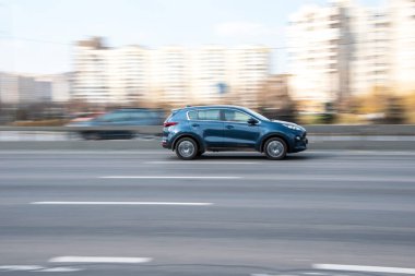 Ukrayna, Kyiv - 4 Nisan 2021: Mavi KIA Spor arabası sokakta hareket ediyor. 