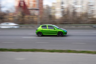 Ukrayna, Kyiv - 6 Nisan 2021: Yeşil Peugeot 206 aracı yolda ilerliyor. 