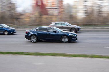 Ukrayna, Kyiv - 6 Nisan 2021: Mavi MAZDA 6 aracı yolda ilerliyor. 