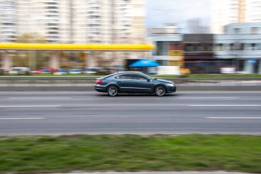 Ukrayna, Kyiv - 6 Nisan 2021: Mavi Volkswagen CC arabası yolda ilerliyor.  