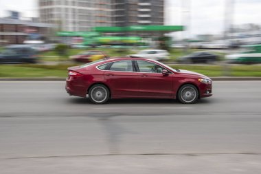 Ukrayna, Kyiv - 20 Nisan 2021: Kırmızı Ford Fusion (Kuzey Amerika) arabası yolda ilerliyor.  