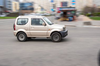 Ukrayna, Kyiv - 20 Nisan 2021: Gümüş renkli Suzuki Jimny arabası yolda ilerliyor.  