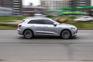 Ukrayna, Kyiv - 20 Nisan 2021: Gümüş Audi e-tron arabası sokakta hareket ediyor.  