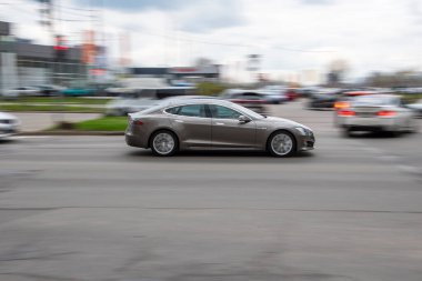 Ukrayna, Kyiv - 20 Nisan 2021: Gümüş renkli TESLA Model S arabası sokakta hareket ediyor.  