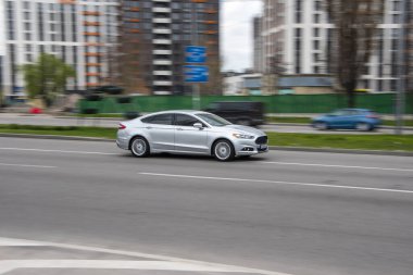 Ukrayna, Kyiv - 20 Nisan 2021: Gümüş Ford Fusion (Kuzey Amerika) arabası sokakta hareket ediyor.  