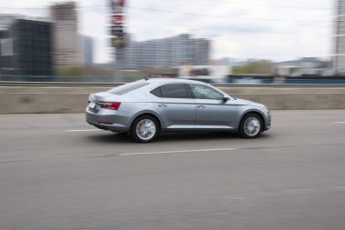 Ukrayna, Kyiv - 20 Nisan 2021: Gümüş rengi Skoda Superb arabası yolda ilerliyor.  