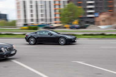 Ukrayna, Kyiv - 20 Nisan 2021: Siyah Aston Martin DB11 aracı yolda ilerliyor.  