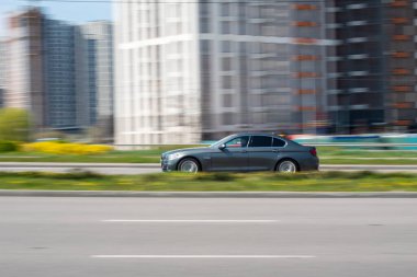 Ukrayna, Kyiv - 20 Nisan 2021: Gri BMW 5 Serisi arabası sokakta hareket ediyor. Yazı