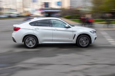Ukrayna, Kyiv - 26 Nisan 2021: Beyaz BMW X6 M araba yolda ilerliyor.  