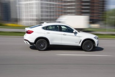Ukrayna, Kyiv - 26 Nisan 2021: Beyaz BMW X6 aracı yolda ilerliyor. Yazı