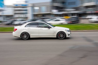 Ukrayna, Kyiv - 26 Nisan 2021: Beyaz Mercedes-Benz C-klasse arabası yolda ilerliyor.  