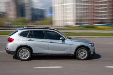 Ukrayna, Kyiv - 26 Nisan 2021: Gümüş renkli BMW X1 arabası sokakta hareket ediyor. Yazı