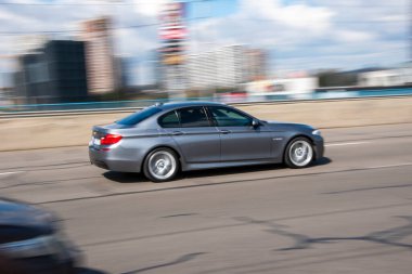 Ukrayna, Kyiv - 26 Nisan 2021: Gri BMW 5 Serisi arabası yolda ilerliyor.  