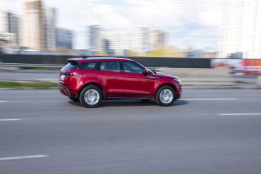 Ukrayna, Kyiv - 26 Nisan 2021: Kırmızı Land Rover Range Evoque aracı caddede ilerliyor. Yazı