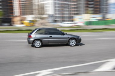 Ukrayna, Kyiv - 26 Nisan 2021: Gri Mitsubishi Caddede hareket eden diğer araba. Yazı